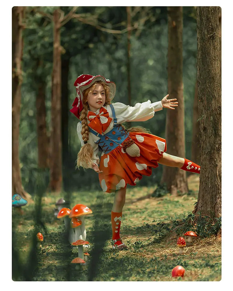A young girl in a whimsical red and orange fairy-style costume dances among red mushrooms in a forest setting.