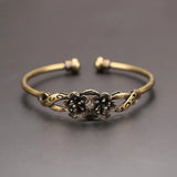 Bronze bracelet with floral design on a gray background