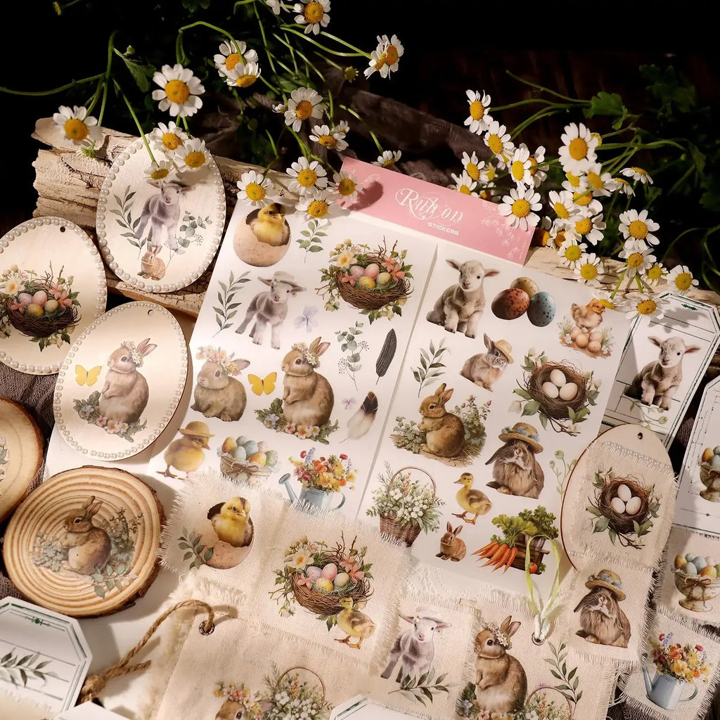 Sheet of Easter-themed stickers with rabbits, eggs, and flowers on a decorative background with plates and flowers.